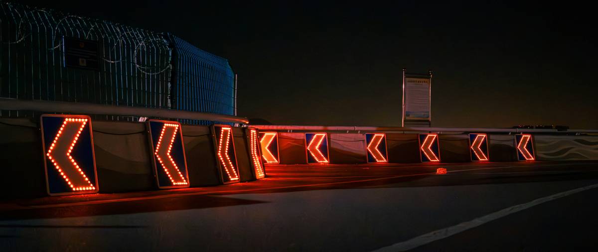 Side-by-side photo: left shows poorly lit wooden house number sign washed out by wide-beam bulb; right shows same sign sharply highlighted with a narrow-beam, high-CRI LED