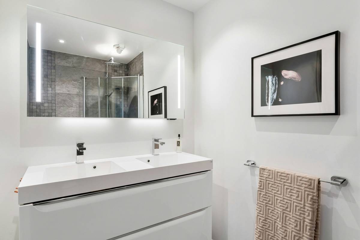 Close-up of mirror cabinet with built in lighting showing edge-lit design and anti-fog feature