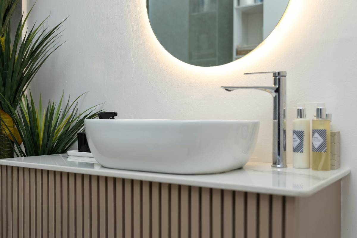 Modern mirror cabinet with built in lighting installed over a bathroom sink